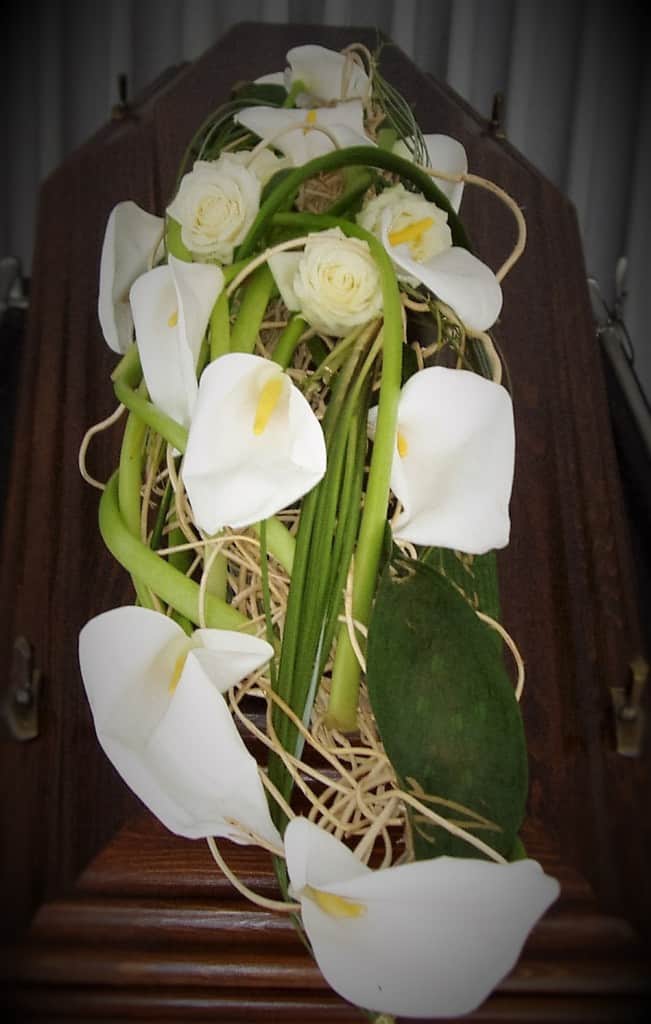 eleganter Sargschmuck aus wißen Calla und weißen Rosen mit gebleichten Ranken